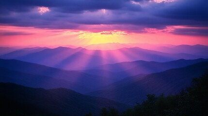 Obraz premium Vibrant sunset casting rays over majestic mountain ranges.