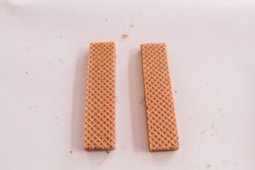 Small chocolate wafer bars, textured, neatly arranged in a row, irregular, snack, long, patterned arrangement, stacked, isolated on background