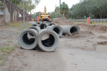 Wide view over large concrete culvert pipe. At a large construction site Water Repair. Yellow...