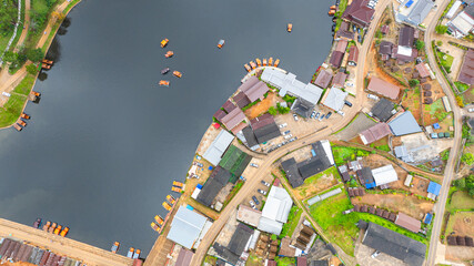 aerial top view of a lakeside village, showcasing a mix of rustic architecture, lush greenery, and...