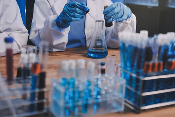Blood test in the laboratory. Laboratory assistant working with the dispenser. Vacuum tubes with...