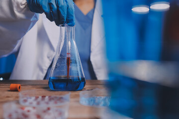 Blood test in the laboratory. Laboratory assistant working with the dispenser. Vacuum tubes with blood.