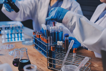 Blood test in the laboratory. Laboratory assistant working with the dispenser. Vacuum tubes with blood.