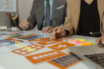 The web design team is consulting to exchange ideas on how to develop digital products, A team of web developers discusses how to best organize a website layout.