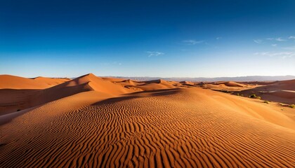 Naklejka premium A serene desert landscape with golden sand dunes under a clear blue sky.
