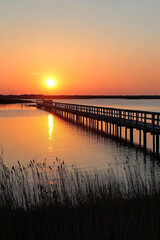 Obraz premium Sunset, a long wooden bridge stretching out into the sea