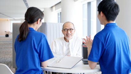 Obraz premium 介護士に説明を受ける高齢者