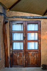 Luxury resort experience, at traditional African game lodge, double wood and glass doors out on traditional rustic villa deck, Lewa Conservancy, Kenya, Africa
