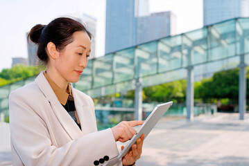 Fototapeta premium Professional Businesswoman Engaged with Tablet in Urban Setting