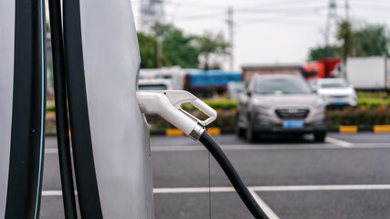 Fuel Nozzle at a Charging Station in a Busy Parking Lot