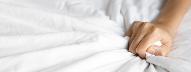 hand of Young couple lover sex intimacy pulling white bedsheet in ecstasy on the bed, orgasm....