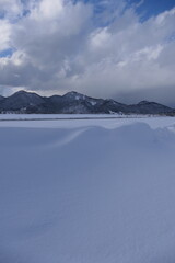 冬の雪山と平原_縦長画像