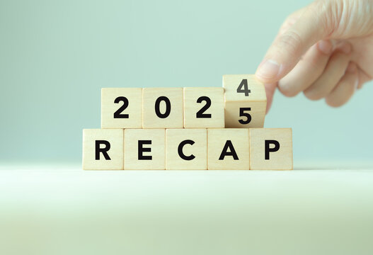 2024 Recap economy, business, financial concept. Business planning in 2025. RECAP text on wooden blocks and hand flipping of 2024 to 2025 on wooden blocks on minimal grey background and copy space.