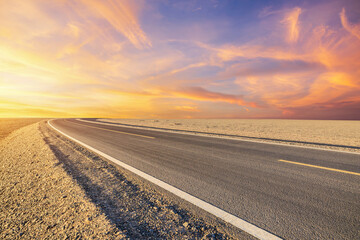 Fototapeta premium Asphalt highway road and desert with beautiful sky clouds natural landscape at sunset in Xinjiang, China. Outdoor road background.