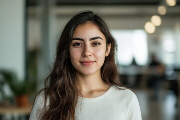 Fototapeta premium Confident Young Woman with Long Hair in a Modern Office Setting