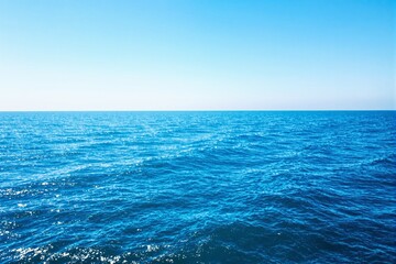 Obraz premium Blue ocean waves reflecting sunlight under a bright clear sky. Scenic and tranquil seascape on a sunny day. Concept of serenity, nature. Ai generative