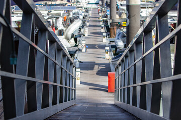walkway to harbor where boats are parked