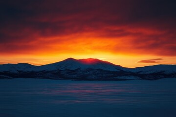 Fototapeta premium Fiery sunset paints the snow-covered mountains with vibrant hues, creating a breathtaking winter landscape.