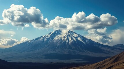 Naklejka premium Majestic Snow-Capped Mountain Peak Under Cumulus Clouds