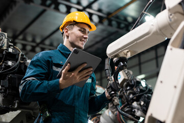 Robotic engineer automatic mechanic checking quality system of automation robot arms machine in factory. Service programming machinery welding robots in production at factory industry.