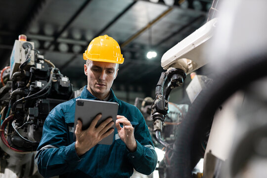 Robotic engineer automatic mechanic checking quality system of automation robot arms machine in factory. Service programming machinery welding robots in production at factory industry.
