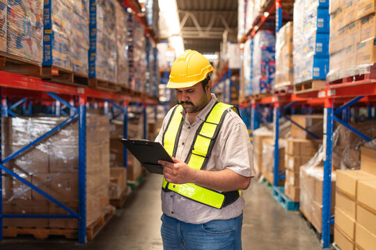 Portrait of male staff with holding clipboard working in warehouse, Industrial and industrial workers concept. - Powered by Adobe