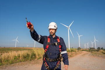 Engineer wearing uniform inspection and survey work in wind turbine farms rotation to generate...