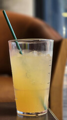 Refreshing iced drink in clear cup with green straw