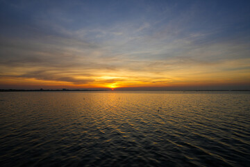 Fototapeta premium Natural Sunset Sunrise Over Sea, Bright Dramatic Sky And Dark Ground. Countryside Landscape Under Scenic Colorful Sky At Sunset Dawn Sunrise. Sun Over Skyline, Horizon. Warm Color.