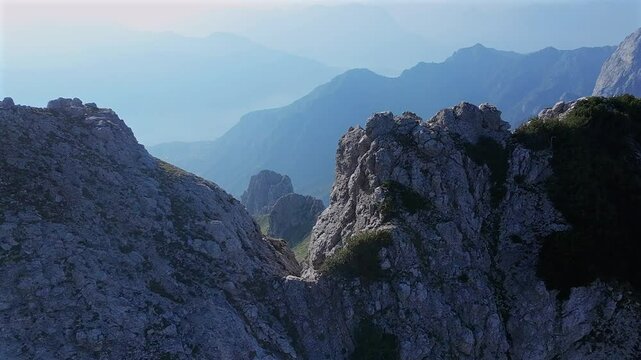 Drone flying over rocky mountain peak, summer season, sunlight, Grignetta, Alps, Italy, Aerial