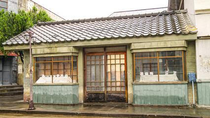 Fototapeta premium Hapcheon-gun, Gyeongsangnam-do, South Korea - tourists are walking on dirt road besides Colonial Japanese House and clothes store at Hapcheon Film Theme Park Morning view of photo studio and shops fo