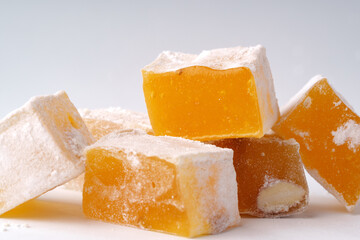 Sweet and chewy confectionery candy pieces stacked on a white background in artistic arrangement