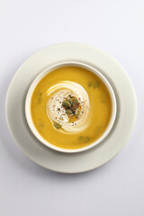 Pumpkin traditional soup with creamy silky texture garnished with pumpkin seeds 