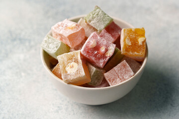 Colorful assortment of traditional confections served in a white bowl on a light background