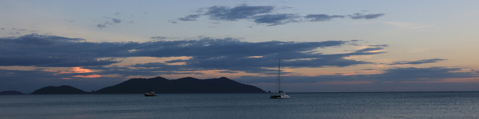 Catamaran and Ko Khlum, small island at sunset view from Klong Kloi Beach, Koh Chang, Thailand.
