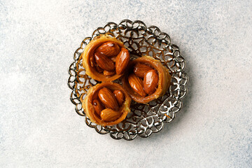 Delicious traditional pastry with almonds served on an ornate plate showcasing intricate design