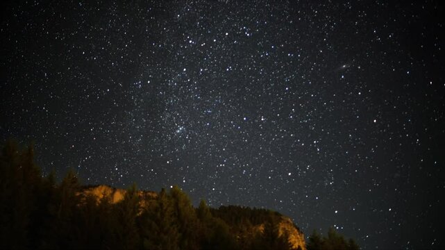 Timelapse of a stunning starry night sky captured in South Tyrol, with a majestic mountain silhouette in the foreground. Perfect for nature, astronomy, or travel-themed projects.