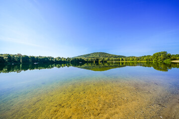 View of the Stockelache natural swimming lake and the surrounding landscape near Borken. Nature by the lake.

