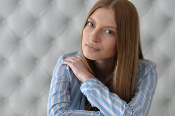 Beauty portrait. Young woman on grey wall background.