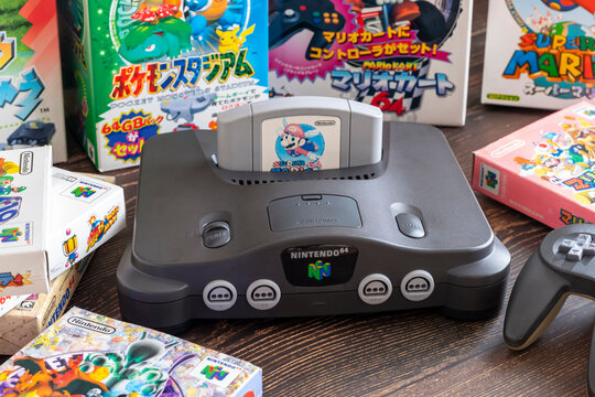Fukuoka, Japan - january 2, 2025 : nintendo N64 and various hit game cartridges on a wooden table