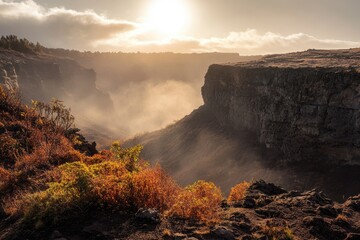 Sunlit volcanic canyon shrouded in morning mist, autumnal hues paint the landscape.