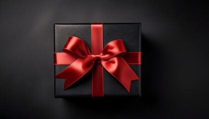 A black gift box adorned with a red ribbon against a black background features a red bow atop it