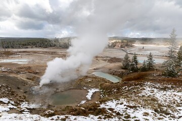 Geothermal area in Yellowstone National Park, with steaming hot springs and snow-covered landscape. Norrie Geyser Basin, Yellowstone National Park, Wyoming, USA.