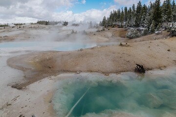 Geothermal pools in Yellowstone National Park, steam rising from the hot springs, a tranquil scene. Norris Geyser Basin, Yellowstone National Park, Wyoming, USA.