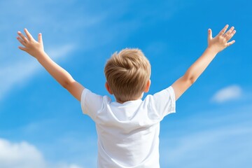 Joyful blonde child raising arms under clear blue sky in sunny day