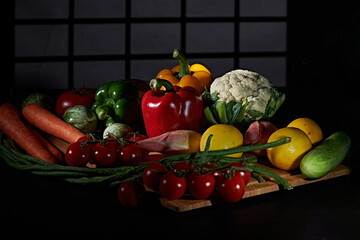 Fresh vegetables for cooking or eating raw photographed against a dark background