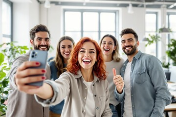 Obraz premium Group of friends taking a selfie indoors, expressing joy and positivity in a bright, modern office setting.