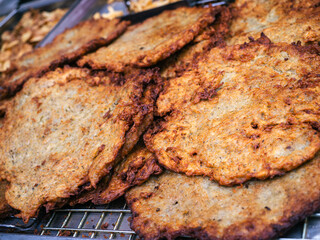 Crispy potato pancakes fried in oil prepared in a large pot at Christmas markets in Bratislava.