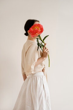 Minimalist Aesthetic. Woman with Peony, Face Obscured, Soft Neutral Tones, Modern Art, Contemporary Fashion