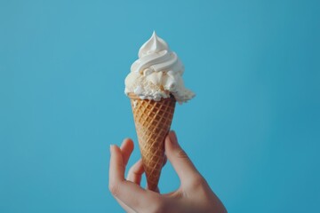 Ice cream  Ice cream cone on a blue background. The woman holding the ice cream by hand.